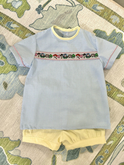 Easton Top in blue gingham with Toy Story ribbon and yellow bias neck, flat lay with yellow shorts