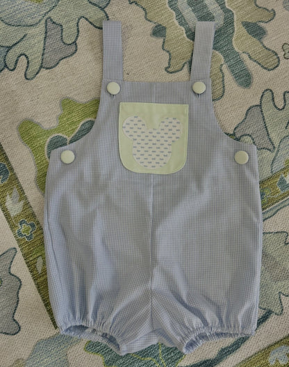 Hudson Romper in blue gingham with Mickey appliqué pocket in light green, flat lay